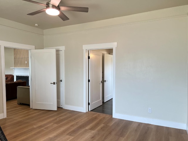 7013 N Maroa Ave, Pinedale, CA 93650 - unfurnished bedroom featuring wood finished floors, a fireplace, and a ceiling fan