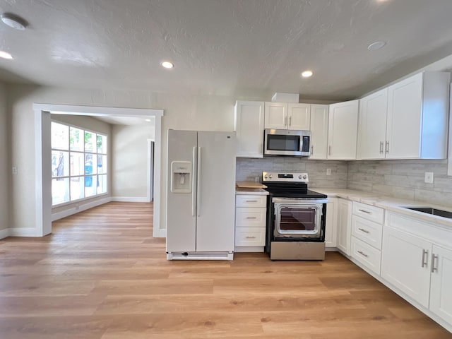 7013 N Maroa Ave, Pinedale, CA 93650 - kitchen with stainless steel appliances, white cabinetry, light countertops, decorative backsplash, and recessed lighting