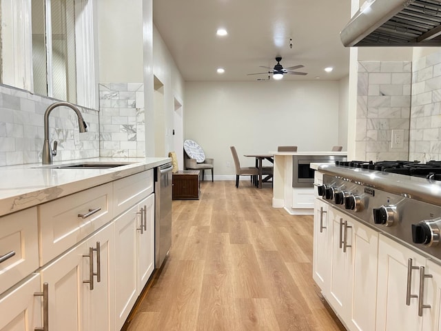 7013 N Maroa Ave, Pinedale, CA 93650 - kitchen with range hood, backsplash, a ceiling fan, light wood-type flooring, and white cabinets