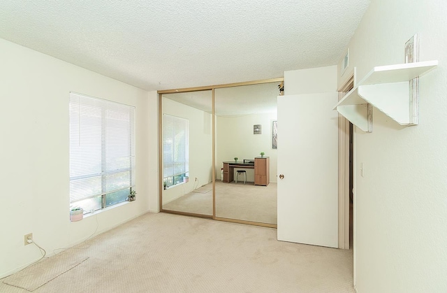 6338 N Maroa Ave Unit 115, Fresno, CA 93704 - unfurnished bedroom with light colored carpet, a closet, and a textured ceiling