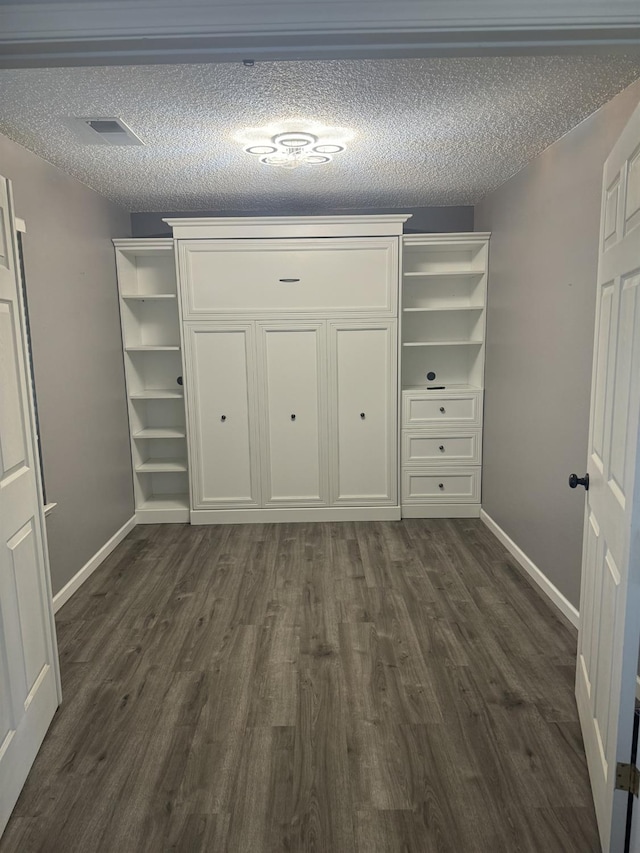 1723 Locust Ave, Clovis, CA 93611 - unfurnished bedroom featuring dark wood-type flooring, a textured ceiling, and a closet