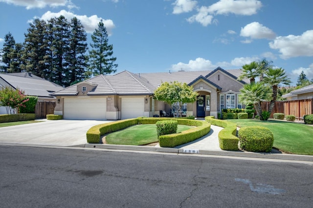 4994 W Minarets Ave, Fresno, CA 93722 - view of front of house featuring driveway, a garage, stucco siding, and a tiled roof