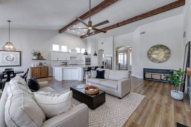 4994 W Minarets Ave, Fresno, CA 93722 - living room featuring arched walkways, a ceiling fan, beamed ceiling, a chandelier, and recessed lighting