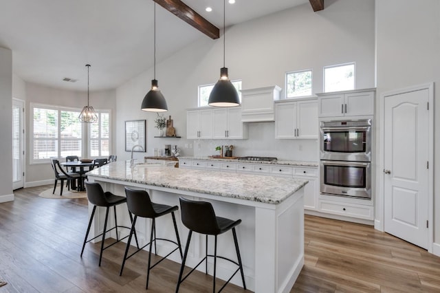 4994 W Minarets Ave, Fresno, CA 93722 - kitchen featuring stainless steel appliances, beam ceiling, high vaulted ceiling, a breakfast bar, and white cabinetry