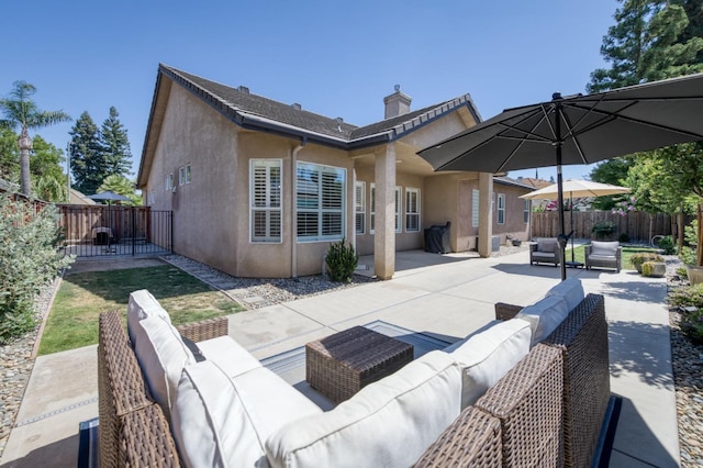4994 W Minarets Ave, Fresno, CA 93722 - rear view of property with outdoor lounge area, stucco siding, a fenced backyard, and a patio area