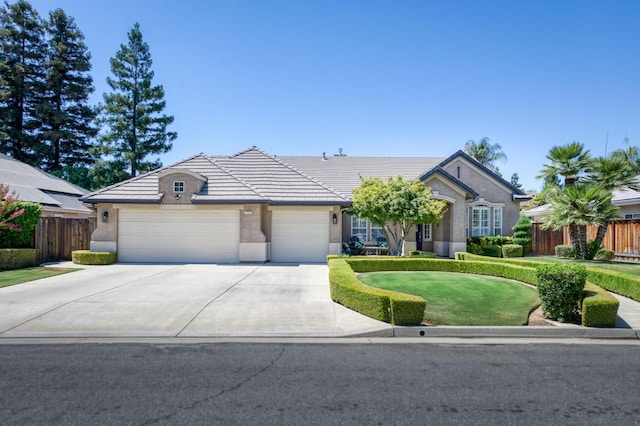 4994 W Minarets Ave, Fresno, CA 93722 - ranch-style home with a garage, concrete driveway, stucco siding, and a tiled roof