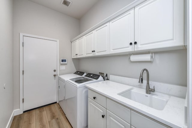 4994 W Minarets Ave, Fresno, CA 93722 - laundry area featuring cabinet space, washer and dryer, and light wood-style floors