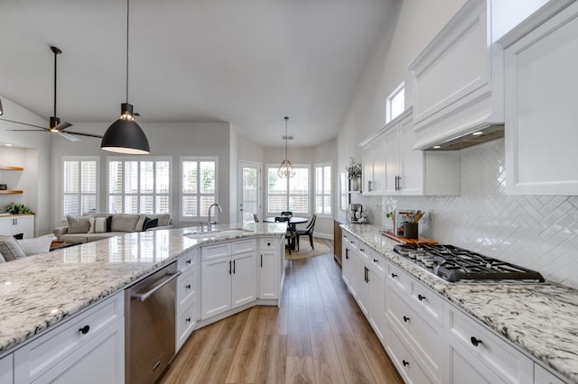4994 W Minarets Ave, Fresno, CA 93722 - kitchen featuring appliances with stainless steel finishes, light wood-type flooring, lofted ceiling, backsplash, and white cabinets