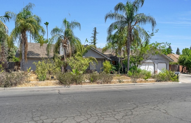1401 S Villa Ave, Fresno, CA 93727 - obstructed view of property with a garage, stucco siding, and driveway