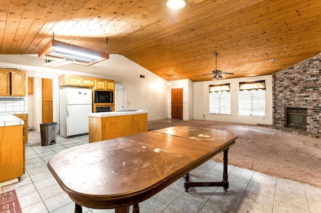 1401 S Villa Ave, Fresno, CA 93727 - dining space with vaulted ceiling, wood ceiling, light tile patterned floors, a fireplace, and a ceiling fan