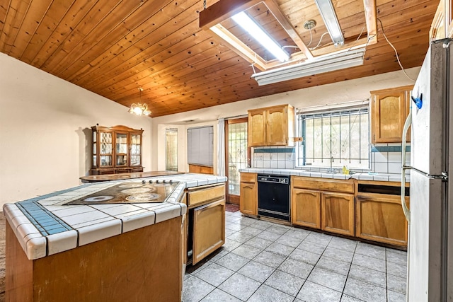 1401 S Villa Ave, Fresno, CA 93727 - kitchen with black dishwasher, freestanding refrigerator, tile counters, lofted ceiling, and light tile patterned floors
