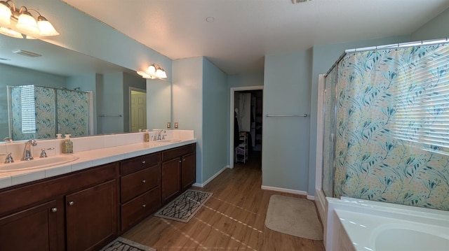 452 Rancho Mirage Rd, Madera, CA 93638 - bathroom featuring a shower with shower curtain, double vanity, a bath, and wood finished floors