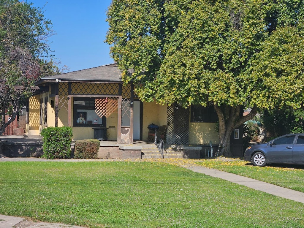 745 E La Sierra, Fresno, CA 93728 - view of front of house featuring a front lawn, stucco siding, and covered porch