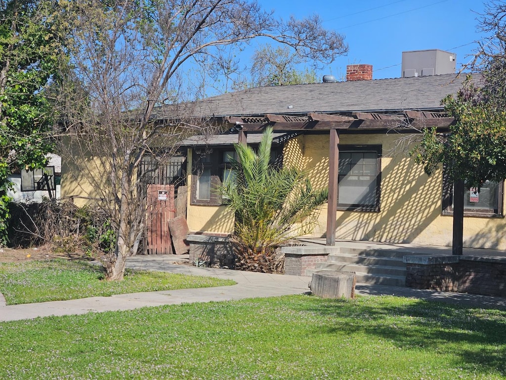 745 E La Sierra, Fresno, CA 93728 - view of front of home featuring a front lawn, roof with shingles, and a chimney