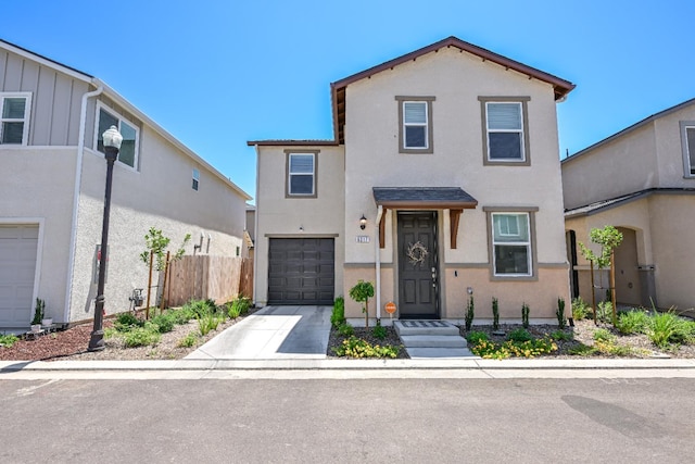 6317 E Malbec Dr, Fresno, CA 93727 - view of front of home with stucco siding, a garage, and driveway