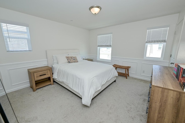 6317 E Malbec Dr, Fresno, CA 93727 - bedroom with a decorative wall, wainscoting, and light carpet