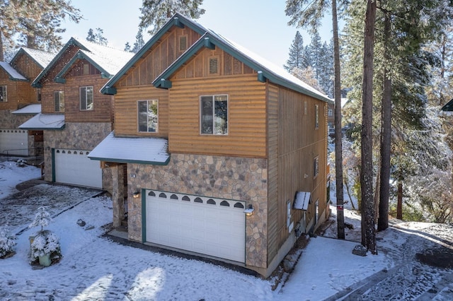 40862 Village Pass Ln, Shaver Lake, CA 93664 - snow covered property featuring stone siding, an attached garage, and board and batten siding