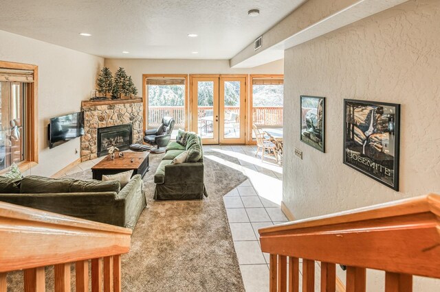 40862 Village Pass Ln, Shaver Lake, CA 93664 - living area with a stone fireplace, a textured wall, a textured ceiling, light tile patterned floors, and french doors