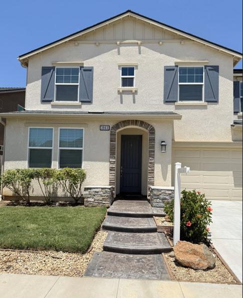 3963 Morris Ave, Clovis, CA 93619 - view of front of house featuring an attached garage, stucco siding, and stone siding