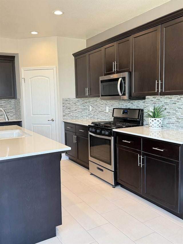 3963 Morris Ave, Clovis, CA 93619 - kitchen with stainless steel appliances, light countertops, backsplash, dark brown cabinetry, and recessed lighting