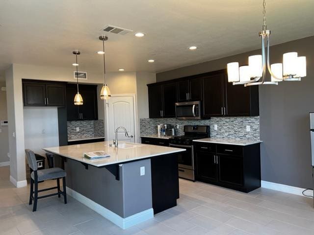 3963 Morris Ave, Clovis, CA 93619 - kitchen with appliances with stainless steel finishes, decorative backsplash, light countertops, recessed lighting, and a kitchen bar