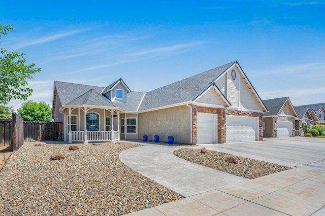 439 W Serena Ave, Clovis, CA 93619 - view of front of home with covered porch, a garage, concrete driveway, a shingled roof, and stone siding