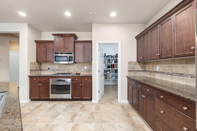3143 Celeste Ave, Clovis, CA 93619 - kitchen featuring appliances with stainless steel finishes, backsplash, dark stone counters, recessed lighting, and light tile patterned floors