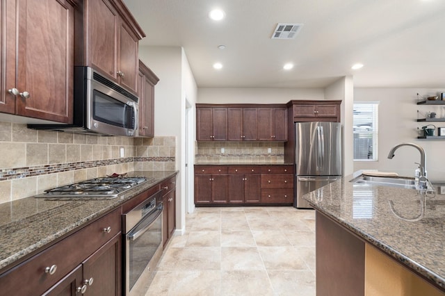 3143 Celeste Ave, Clovis, CA 93619 - kitchen with stainless steel appliances, decorative backsplash, dark stone counters, recessed lighting, and dark brown cabinets