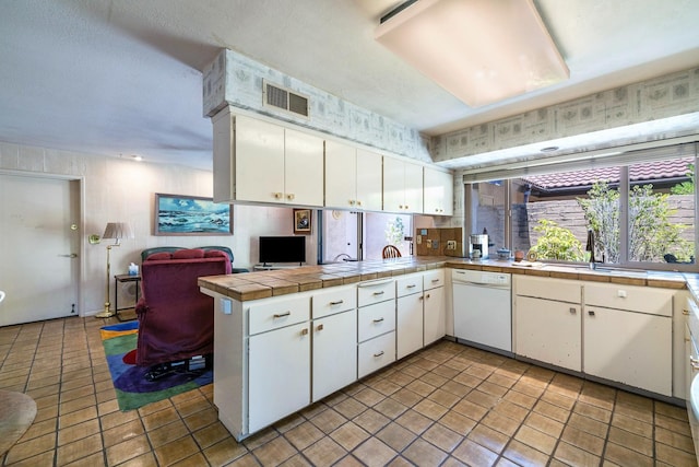 5630 N El Adobe Dr, Fresno, CA 93711 - kitchen with white dishwasher, a peninsula, white cabinetry, and tile countertops