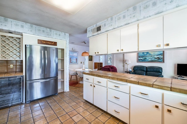 5630 N El Adobe Dr, Fresno, CA 93711 - kitchen with freestanding refrigerator, beverage cooler, white cabinets, open floor plan, and backsplash
