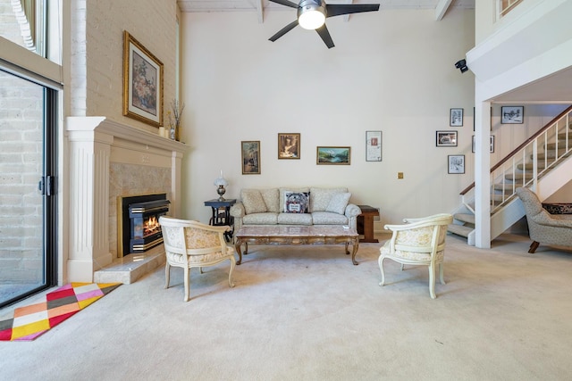 5630 N El Adobe Dr, Fresno, CA 93711 - living room featuring a towering ceiling, light colored carpet, a ceiling fan, a tile fireplace, and stairway