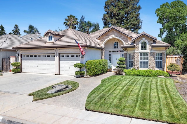8194 N 5th St, Fresno, CA 93720 - view of front of house with stucco siding, a garage, concrete driveway, and a tile roof