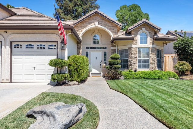 8194 N 5th St, Fresno, CA 93720 - view of front of house featuring stucco siding, an attached garage, stone siding, and a tiled roof