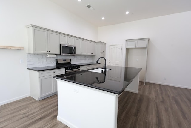 879 Hermosa Ave, Clovis, CA 93619 - kitchen with appliances with stainless steel finishes, dark countertops, wood finished floors, tasteful backsplash, and recessed lighting