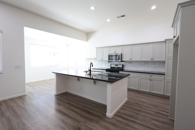 879 Hermosa Ave, Clovis, CA 93619 - kitchen with appliances with stainless steel finishes, backsplash, dark countertops, dark wood-style flooring, and recessed lighting
