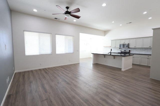 879 Hermosa Ave, Clovis, CA 93619 - kitchen with stainless steel appliances, dark countertops, open floor plan, recessed lighting, and dark wood-style flooring