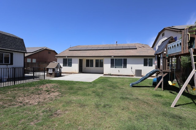 879 Hermosa Ave, Clovis, CA 93619 - rear view of house with a playground, a patio area, roof mounted solar panels, a fenced backyard, and stucco siding