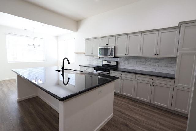 879 Hermosa Ave, Clovis, CA 93619 - kitchen featuring appliances with stainless steel finishes, tasteful backsplash, dark countertops, dark wood-style floors, and gray cabinets