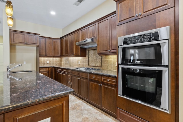 5857 W Modoc, Visalia, CA 93291 - kitchen featuring stainless steel appliances, tasteful backsplash, dark stone counters, under cabinet range hood, and hanging light fixtures