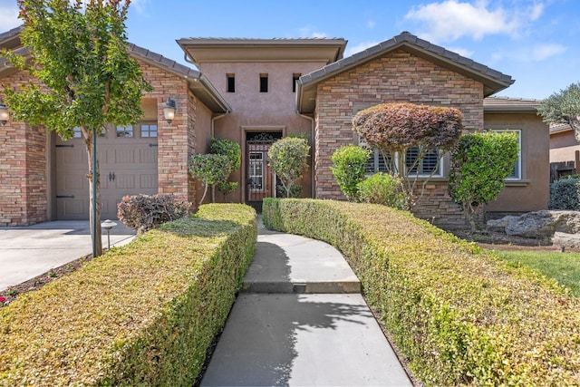 5857 W Modoc, Visalia, CA 93291 - view of front of house with a garage, stucco siding, driveway, a tile roof, and stone siding