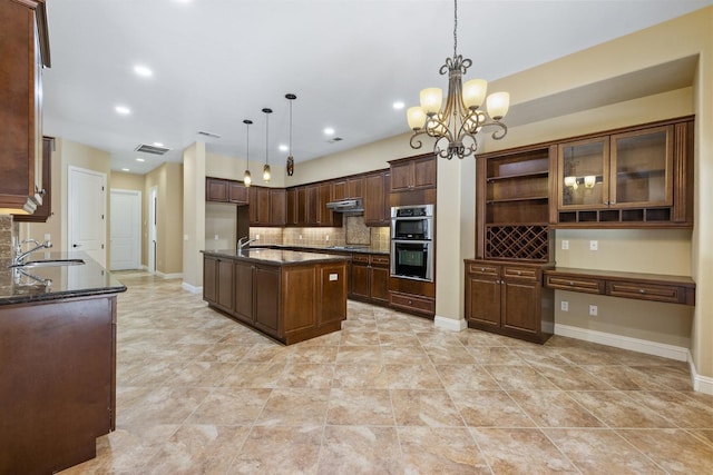 5857 W Modoc, Visalia, CA 93291 - kitchen with under cabinet range hood, decorative backsplash, cooktop, stainless steel double oven, and open shelves