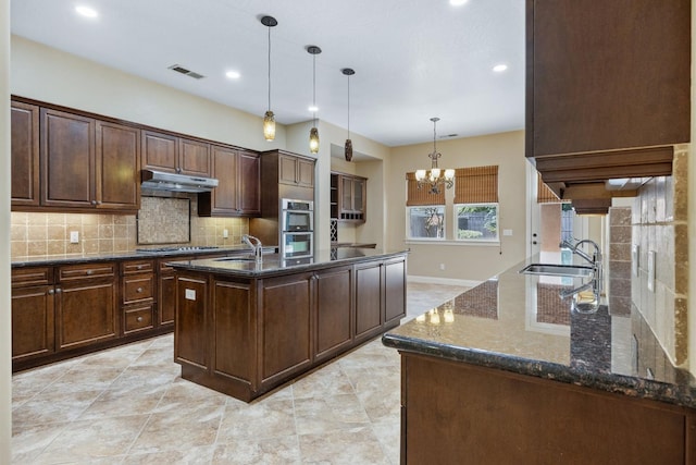 5857 W Modoc, Visalia, CA 93291 - kitchen featuring under cabinet range hood, stainless steel appliances, backsplash, a chandelier, and dark stone counters