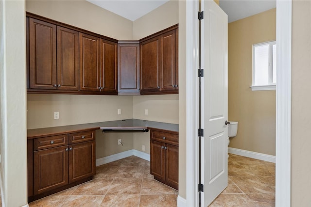 5857 W Modoc, Visalia, CA 93291 - kitchen with built in study area, dark countertops, dark brown cabinets, and light tile patterned flooring