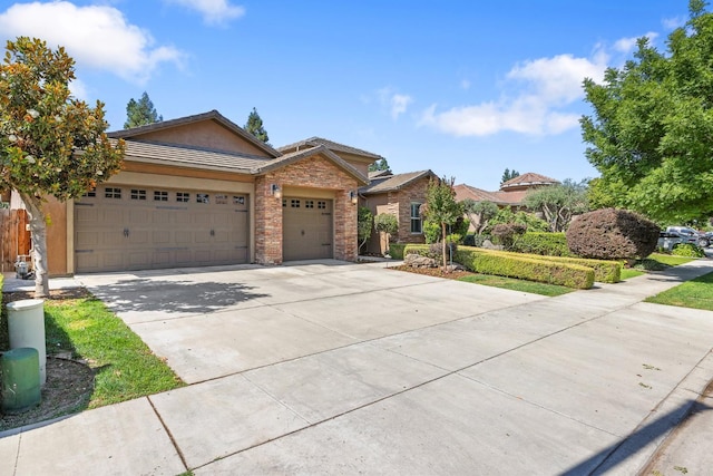 5857 W Modoc, Visalia, CA 93291 - view of front facade featuring driveway, a garage, stucco siding, and stone siding