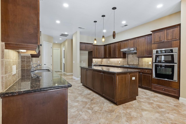 5857 W Modoc, Visalia, CA 93291 - kitchen featuring under cabinet range hood, dark stone counters, decorative backsplash, double oven, and recessed lighting