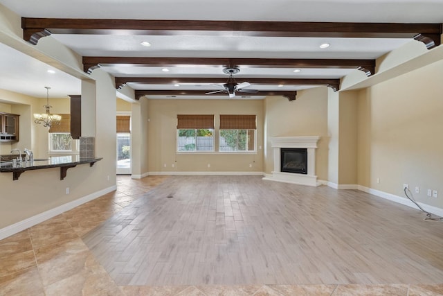 5857 W Modoc, Visalia, CA 93291 - unfurnished living room featuring a ceiling fan, a chandelier, recessed lighting, a glass covered fireplace, and beamed ceiling