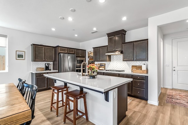 4086 Dennis Ave, Clovis, CA 93619 - kitchen featuring stainless steel appliances, light wood finished floors, light countertops, decorative backsplash, and recessed lighting