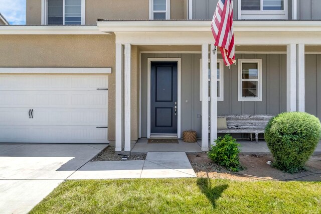 4086 Dennis Ave, Clovis, CA 93619 - entrance to property featuring board and batten siding, an attached garage, concrete driveway, stucco siding, and covered porch