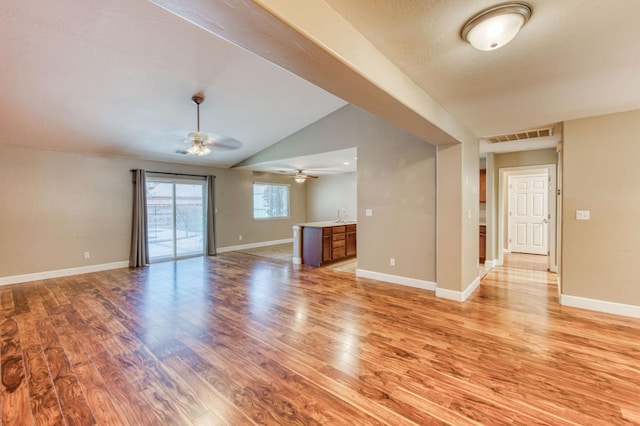 564 S Duke Ave, Fresno, CA 93727 - unfurnished living room with light wood finished floors, ceiling fan, and vaulted ceiling