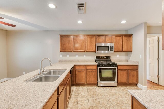 564 S Duke Ave, Fresno, CA 93727 - kitchen featuring stainless steel appliances, brown cabinetry, light countertops, a ceiling fan, and recessed lighting